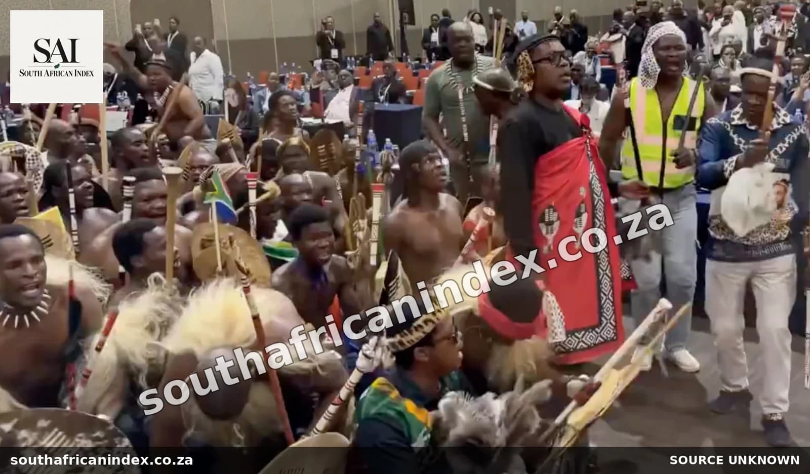 Ngizwe Mchunu in traditional attire among disruptors carrying shields and sticks inside the Durban ICC auditorium.