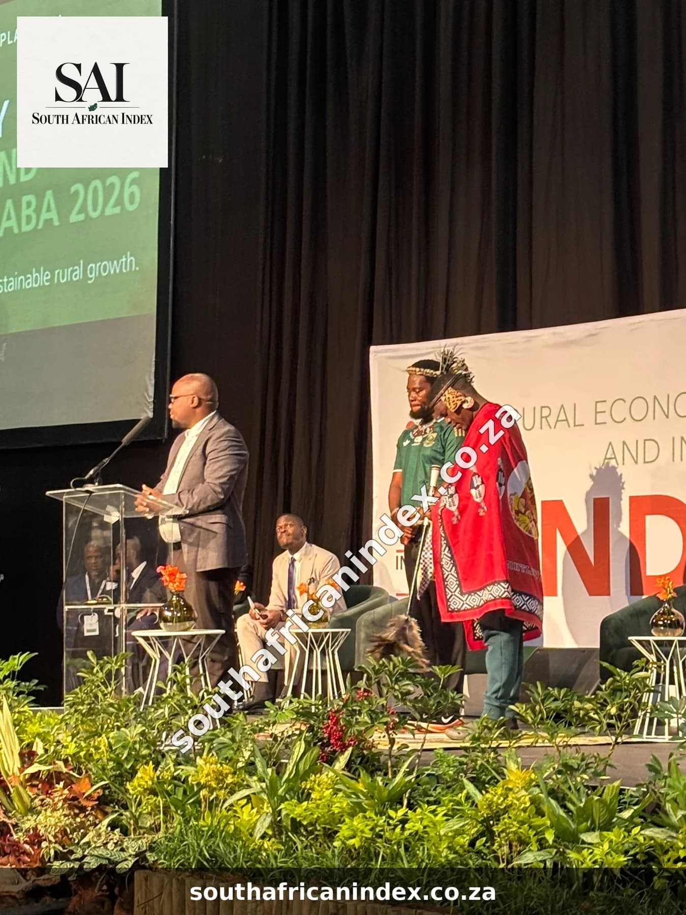 Phakelumthakathi and Ngizwe Mchunu standing on stage beside the lectern before their apology.